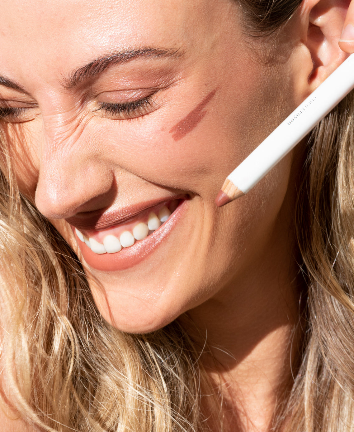 gentle hydrating coco crayon by Ere Perez applied on skin and in its waste-free crayon for a natural warm colour   
